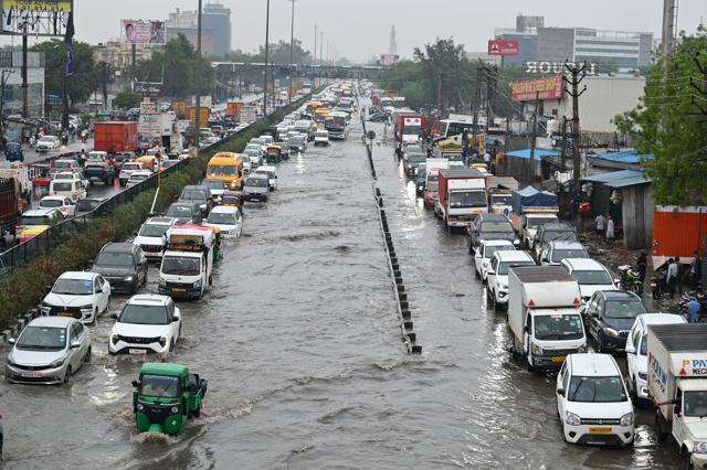 Vehicles wade through a flooded stretch of NH-48 near Narsinghpur village on Tuesday. (Parveen Kumar/HT) Vehicles wade through a flooded stretch of NH-48 near Narsinghpur village on Tuesday. (Parveen Kumar/HT)