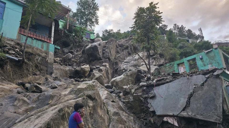 A resident walking through boulders and debris strewn across a locality at Thathri after the midnight mayhem. (PTI Photo)