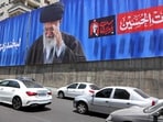 Commuters drive past a giant billboard bearing a picture of Iran's late supreme leader Ayatollah Ali Khamenei ahead of his funeral, in Tehran on July 2.
