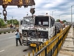 A crane removes the damaged trailer truck involved in the accident in which three children and their father were killed after it allegedly ran over a family on the Delhi-Ajmer Highway, in Jaipur.