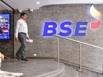 A security personnel with a sniffer dog keeps vigil as people walk out of the Bombay Stock Exchange building in Mumbai.