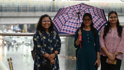 Gram it: Come rain or shine, smile! These Delhiites were spotted enjoying the recent showers at Tilak Marg, as rain arrived in the city after days of hot and humid weather. The IMD has issued a forecast of cloudy sky and very light rain for today as well. (Photo: Arvind Yadav/HT)
