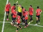 Referee Francois Letexier, of France, shows a yellow card during the World Cup round of 16 soccer match between Argentina and Egypt in Atlanta