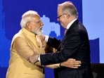 Australia's Prime Minister Anthony Albanese (R) and Indian Prime Minister Narendra Modi greet each other on stage during a community event at Docklands Stadium in Melbourne on July 9, 2026. 