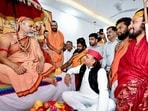 Samajwadi Party president Akhilesh Yadav meets and seeks blessings of spiritual leader Swami Avimukteshwaranand Saraswati at the latter’s programme, in Lucknow on Thursday. (@yadavakhilesh X/ANI Photo)