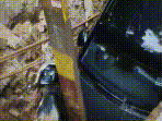 A parked car and a scooter plunged into the pit, while a nearby electricity pole tilted towards the crater.