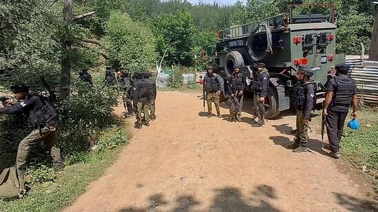 Security personnel at the site as the body of a terrorist recovered following an encounter with security forces, in Shopian on Wednesday. (ANI Video Grab)