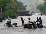 Commuters make their way through a waterlogged road following heavy rain, in the Gazipur area of New Delhi, on Thursday morning, July 9, 2026.