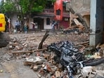 Authorities clear debris at the site of the building collapse in Rohini during the morning in New Delhi, India.