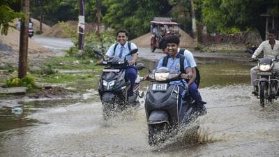Students move on a waterlogged road in Mirzapur. (PTI PHOTO) Students move on a waterlogged road in Mirzapur. (PTI PHOTO)