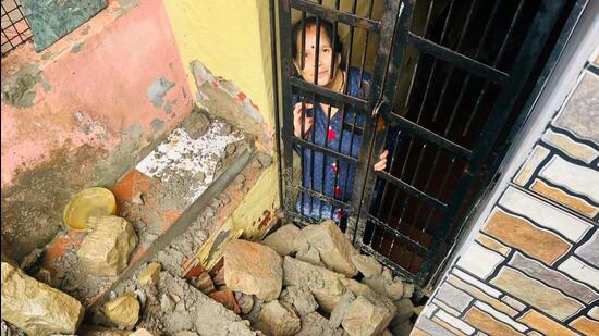 A woman trapped in her house after a retaining wall collapsed near Bada Chowk in Nahan in Sirmaur district amid incessant rain on Friday. The collapse sent debris crashing down, blocking the passage and jamming doors and windows of houses. (HT Photo)