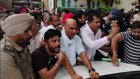 BJP leaders and councillors surrounding the official vehicles of the Ferozepur divisional commissioner and the Fazilka deputy commissioner, preventing them from leaving the Abohar MC office on Friday. (HT)