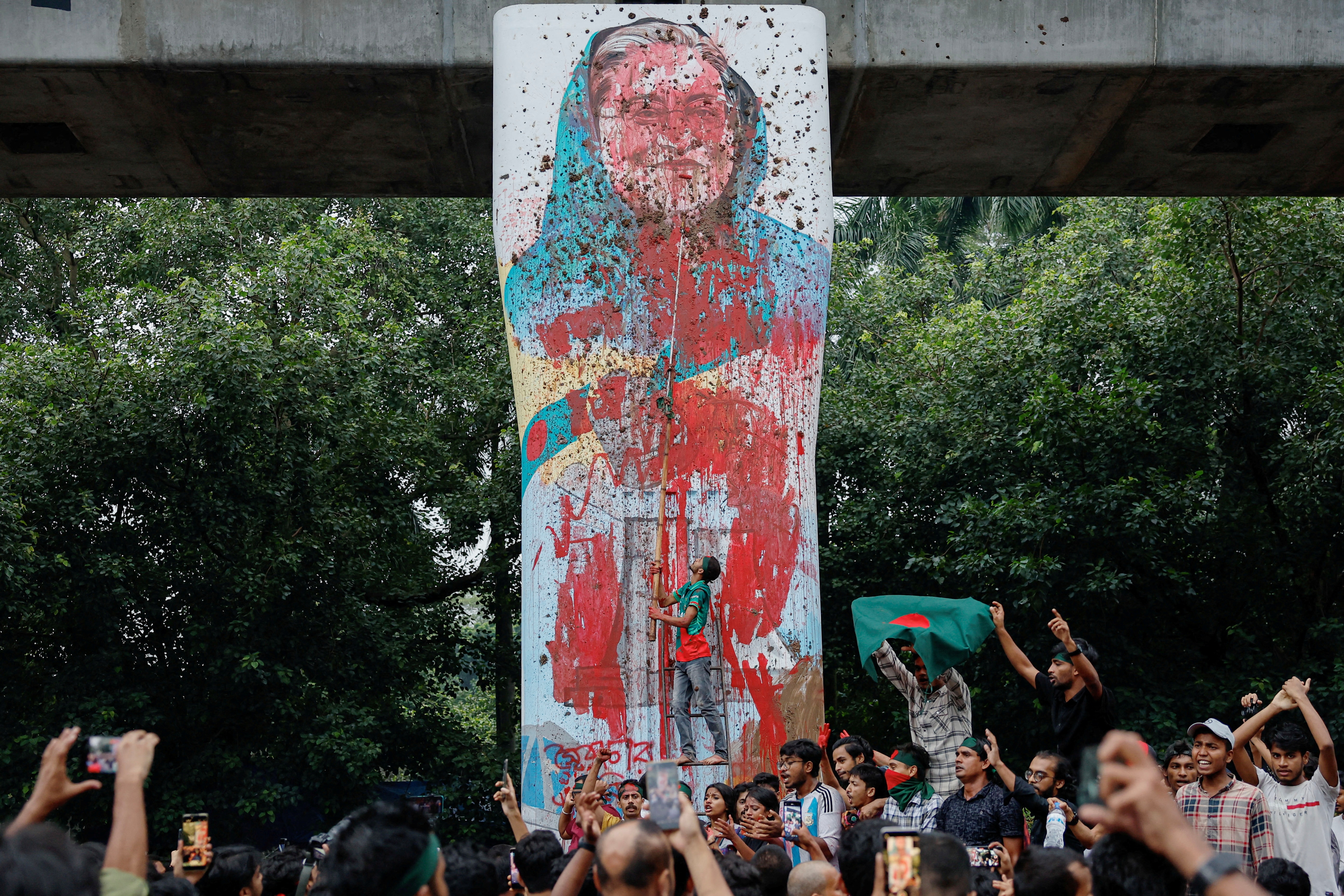FILE PHOTO: Protesters shout slogans as they vandalise a mural of Bangladeshi Prime Minister Sheikh Hasina with paint and mud, demanding her resignation at Teacher Student Center (TSC) area of University of Dhaka in Dhaka, Bangladesh, August 3, 2024. (REUTERS)