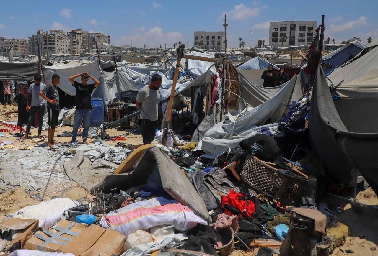 Palestinians inspect the site of an Israeli strike on a tent encampment in Gaza City. Palestinians inspect the site of an Israeli strike on a tent encampment in Gaza City.