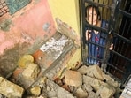 A woman trapped in her house after a retaining wall collapsed near Bada Chowk in Nahan in Sirmaur district amid incessant rain on Friday. The collapse sent debris crashing down, blocking the passage and jamming doors and windows of houses. (HT Photo)