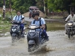 Students move on a waterlogged road in Mirzapur. (PTI PHOTO)