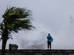 A person looks on as large waves crash against the coast as Typhoon Bavi passes off northeastern Taiwan.