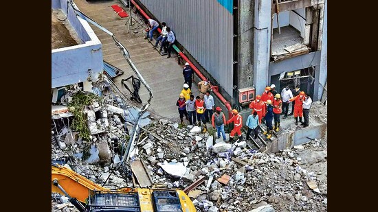 NDRF personnel at the site after a three-storey administrative building of a Waste-to-Energy (WTE) plant run by the Pimpri Chinchwad Municipal Corporation collapsed when an adjacent mound of garbage fell onto the structure like a landslide, in Pune district, Maharashtra, Saturday. (PTI)