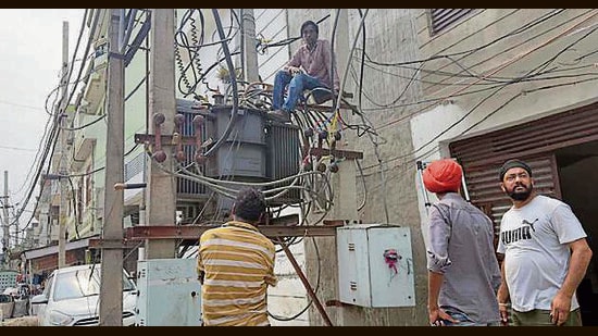 Linemen repairing a transformer in Ludhiana. (HT File)