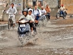 Commuters making their way through rain in Amritsar on Sunday. (Sameer Sehgal/HT)
