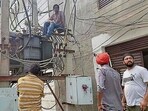 Linemen repairing a transformer in Ludhiana. (HT File)
