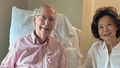 Mitch McConnell sits with his wife, former United States secretary of labor Elaine Chao, while holding what appears to be the July 12 sports section of the Washington Post. (Mitch McConnell's office via REUTERS)