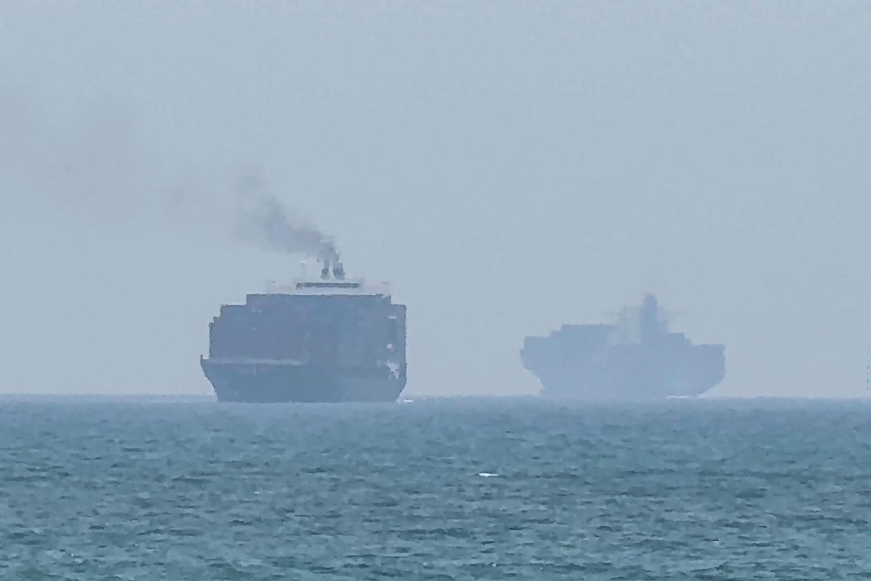 TOPSHOT - This frame grab taken from AFPTV video footage on July 12, 2026 shows cargo ships anchoring near the Strait of Hormuz off the eastern coast of the United Arab Emirates at Khor Fakkan. Tehran announced it was closing the Strait of Hormuz on July 12 and launched missiles and drones at its Gulf neighbours, in retaliation for new US strikes following an attack by Iranian forces on a merchant vessel that was abandoned in flames by its crew. (Photo by AFPTV / AFP) / Attention editors: AFP covers the war in the Middle East through its extensive regional network, including bureaus in Tehran, Jerusalem and several neighboring countries.Since the start of the conflict, journalists have been working under increasingly restrictive conditions. Authorities in several countries have limited reporters� movements, photo and live video coverage from sensitive locations. Some governments and armed groups have banned images of missile or drone strikes and other security-related sites. / (AFP) TOPSHOT - This frame grab taken from AFPTV video footage on July 12, 2026 shows cargo ships anchoring near the Strait of Hormuz off the eastern coast of the United Arab Emirates at Khor Fakkan. Tehran announced it was closing the Strait of Hormuz on July 12 and launched missiles and drones at its Gulf neighbours, in retaliation for new US strikes following an attack by Iranian forces on a merchant vessel that was abandoned in flames by its crew. (Photo by AFPTV / AFP) / Attention editors: AFP covers the war in the Middle East through its extensive regional network, including bureaus in Tehran, Jerusalem and several neighboring countries.Since the start of the conflict, journalists have been working under increasingly restrictive conditions. Authorities in several countries have limited reporters� movements, photo and live video coverage from sensitive locations. Some governments and armed groups have banned images of missile or drone strikes and other security-related sites. / (AFP)