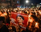 (FILES) A protester holds a poster with an image of detained civilian leader Aung San Suu Kyi during a candlelight vigil to honour those who have died during demonstrations against the military coup in Yangon on March 13, 2021. Myanmar's junta-chief turned president on April 30, 2026 ordered deposed leader Aung San Suu Kyi to be moved to house arrest, five years after sweeping her into detention in a 2021 coup.