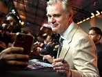 British-American filmmaker Christopher Nolan (R) poses with a fan upon his arrival to attend the red carpet for the premiere of the film 'The Odyssey' in Mumbai on July 11, 2026.
