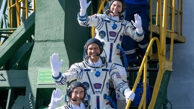 Expedition 75 Roscosmos astronaut Anna Kikina, top, NASA astronaut Anil Menon, center, and Roscosmos astronaut Pyotr Dubrov, bottom, wave goodbye before boarding the Soyuz MS-29 spacecraft for launch, Tuesday, July 14, 2026, at Baikonur Cosmodrome in Kazakhstan. Access Point/PTI(AP07_14_2026_000434A) (Access Point) Expedition 75 Roscosmos astronaut Anna Kikina, top, NASA astronaut Anil Menon, center, and Roscosmos astronaut Pyotr Dubrov, bottom, wave goodbye before boarding the Soyuz MS-29 spacecraft for launch, Tuesday, July 14, 2026, at Baikonur Cosmodrome in Kazakhstan. Access Point/PTI(AP07_14_2026_000434A) (Access Point)