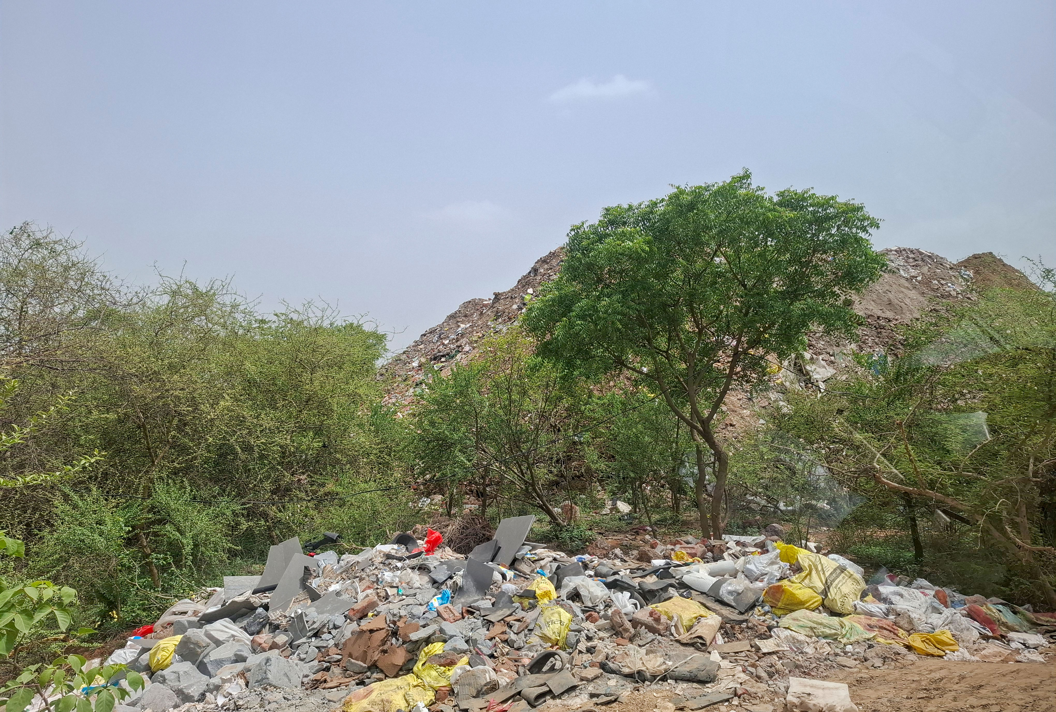 Illegally dumped construction and demolition waste seen behind the biodiversity park near DLF Ph-3 seen on Monday. (Parveen Kumar/HT) Illegally dumped construction and demolition waste seen behind the biodiversity park near DLF Ph-3 seen on Monday. (Parveen Kumar/HT)
