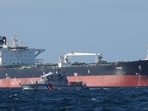 A French Navy vessel sails by the Russian oil tanker “Tagor”, suspected of flying a false Cameroonian flag and boarded by the French Navy on May 31 as it arrives in Douarnenez Bay, western France on June 2. (AFP)