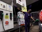 A worker fills a car with petrol as he gestures towards the fuel barometer for the passenger to check, at a fuel station in Kolkata.(Reuters File)