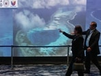 People pass by an electronic board showing areas of the disputed South China Sea during a conference to mark the 10th anniversary of a 2016 arbitration ruling which invalidated China's expansive claims during a conference in Manila, Philippines.