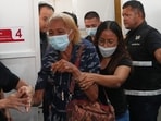 A relative of a victim in a music bar fire cries while receiving the victim's body at a police hospital in Bangkok, Thailand, Wednesday, July 15, 2026. 