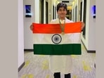 The 17-year-old, Rishit, poses with the Indian flag and his gold medal.