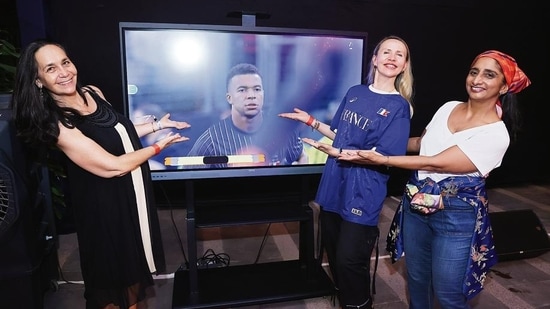 L-R: Kareen Cappai, Kateryna Bila and director of Alliance Française de Delhi, Patricia Loison, cheering for French captain Kylian Mbappé before the match
