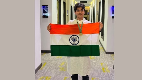 The 17-year-old, Rishit, poses with the Indian flag and his gold medal.