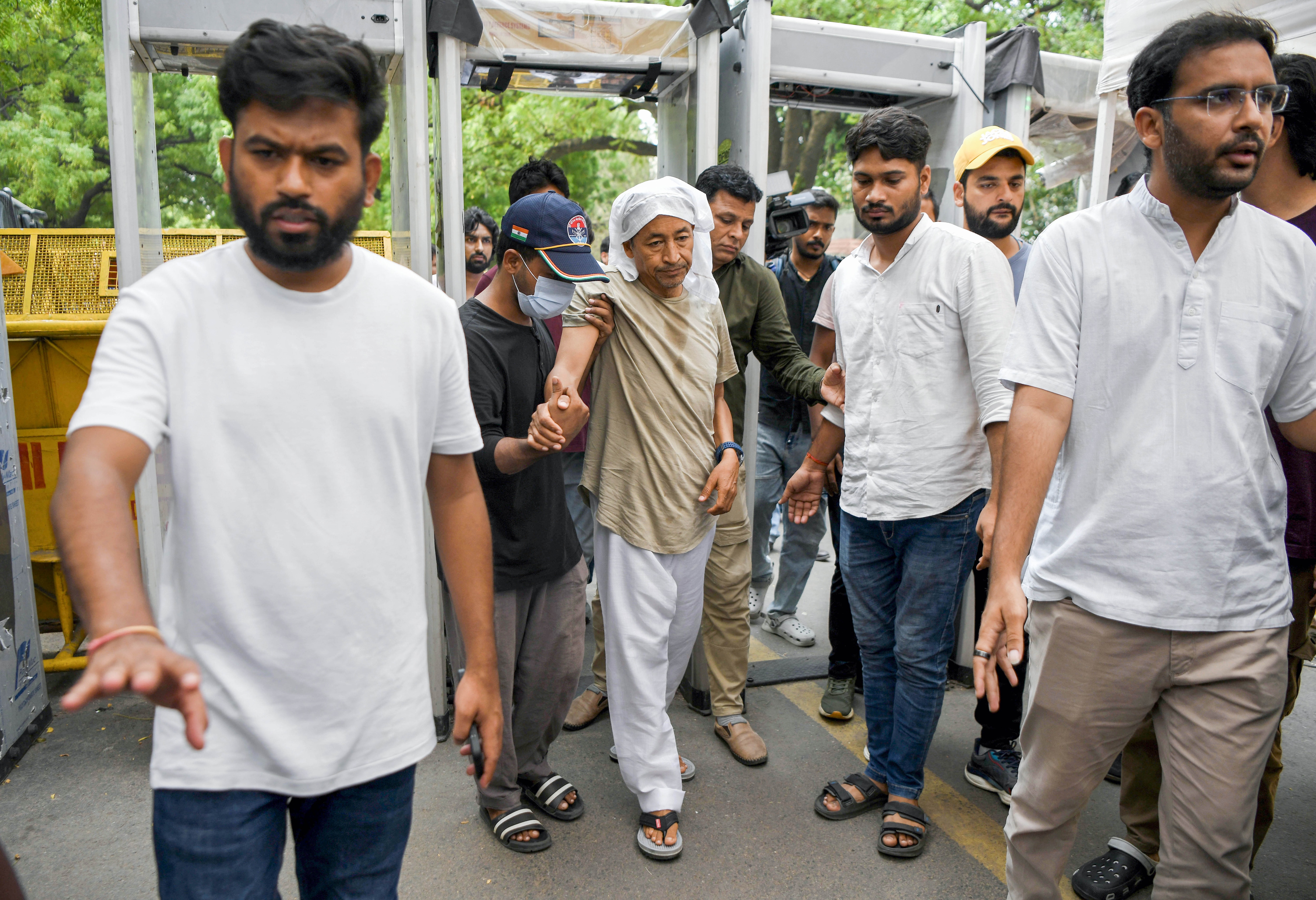Abhijeet Dipke clearing the way, activist Sonam Wangchuk walks with help on the 18th day of his hunger strike during the Cockroach Janata Party's (CJP) protest at Jantar Mantar in New Delhi on Wednesday. (Rahul Singh/ANI Photo) Abhijeet Dipke clearing the way, activist Sonam Wangchuk walks with help on the 18th day of his hunger strike during the Cockroach Janata Party's (CJP) protest at Jantar Mantar in New Delhi on Wednesday. (Rahul Singh/ANI Photo)