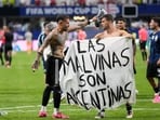 Argentina's Giovani Lo Celso holds a banner with the words 