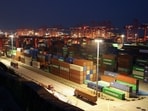 Gantry cranes stand near stacked shipping containers at Yangshan Port outside Shanghai, China, May 7, 2026