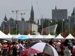 People on the grounds of LeBreton Flats in front of Parliament Hill on Canada Day in Ottawa, Ontario, on July 1. (Photograph for representative purpose only) (Bloomberg)