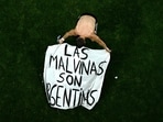 Argentina's midfielder #11 Giovani Lo Celso adjusts a banner reading "The Malvinas (Falkland Islands) belong to Argentina," after winning the 2026 World Cup football tournament semi-final match between England and Argentina at the Atlanta Stadium in Atlanta on July 15.