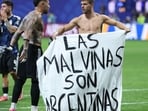 Argentina's defender #19 Nicolas Otamendi (L) and midfielder #11 Giovani Lo Celso show a banner that reads in Spanish, "The Malvinas (Falkland Islands) belong to Argentina," (Photo by Thomas COEX / AFP)