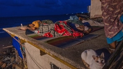 मुंबई में गर्म और आर्द्र परिस्थितियों के बीच घर के अंदर की भीषण गर्मी से बचने के लिए निवासी वर्सोवा बीच के पास अपने घर की छत पर सोते हैं (एपी फोटो/रफीक मकबूल)