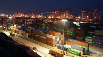 Gantry cranes stand near stacked shipping containers at Yangshan Port outside Shanghai, China, May 7, 2026 (REUTERS)