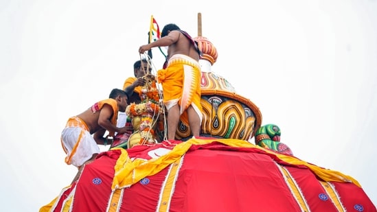 Priests adorn the chariot of Lord Jagannath with a floral garland on the occasion of Mahaprabhu Jagannath Rath Yatra at Puri Jagannath temple, in Puri on Thursday. (@JagannathaDhaam X/ANI Photo)