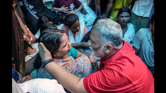 Independent MP Rajesh Ranjan alias Pappu Yadav consoles a breaved family member of Bunty Yadav, who was allegedly abducted by unidentified people on July 6th and whose body was found five days later in the Athmalgola area of Patna district, during a meeting, in Patna on Wednesday. (PTI)
