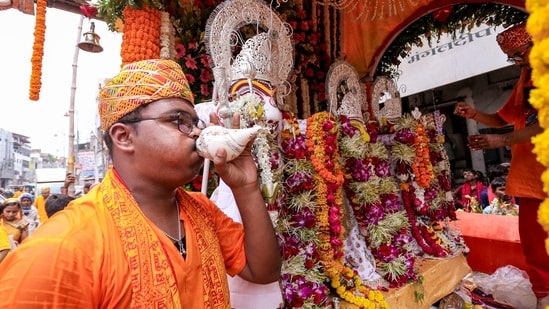 A priest blows a conch as the idols of Lord Jagannath, Lord Balabhadra and Goddess Subhadra are carried during the annual Jagannath Rath Yatra procession, in Prayagraj, Thursday, July 16.&nbsp;(PTI)
