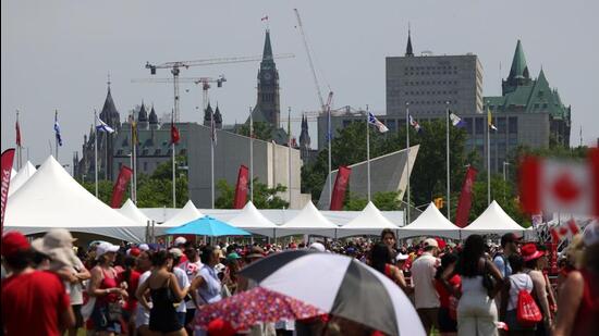 People on the grounds of LeBreton Flats in front of Parliament Hill on Canada Day in Ottawa, Ontario, on July 1. (Photograph for representative purpose only) (Bloomberg)